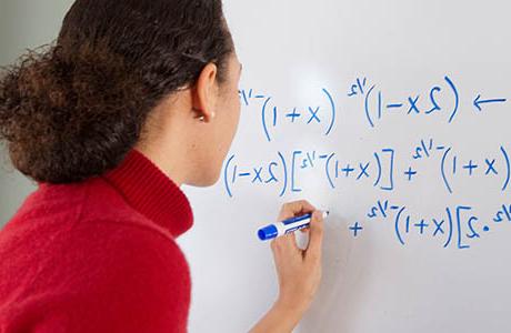 Woman writing a math formula on a whiteboard